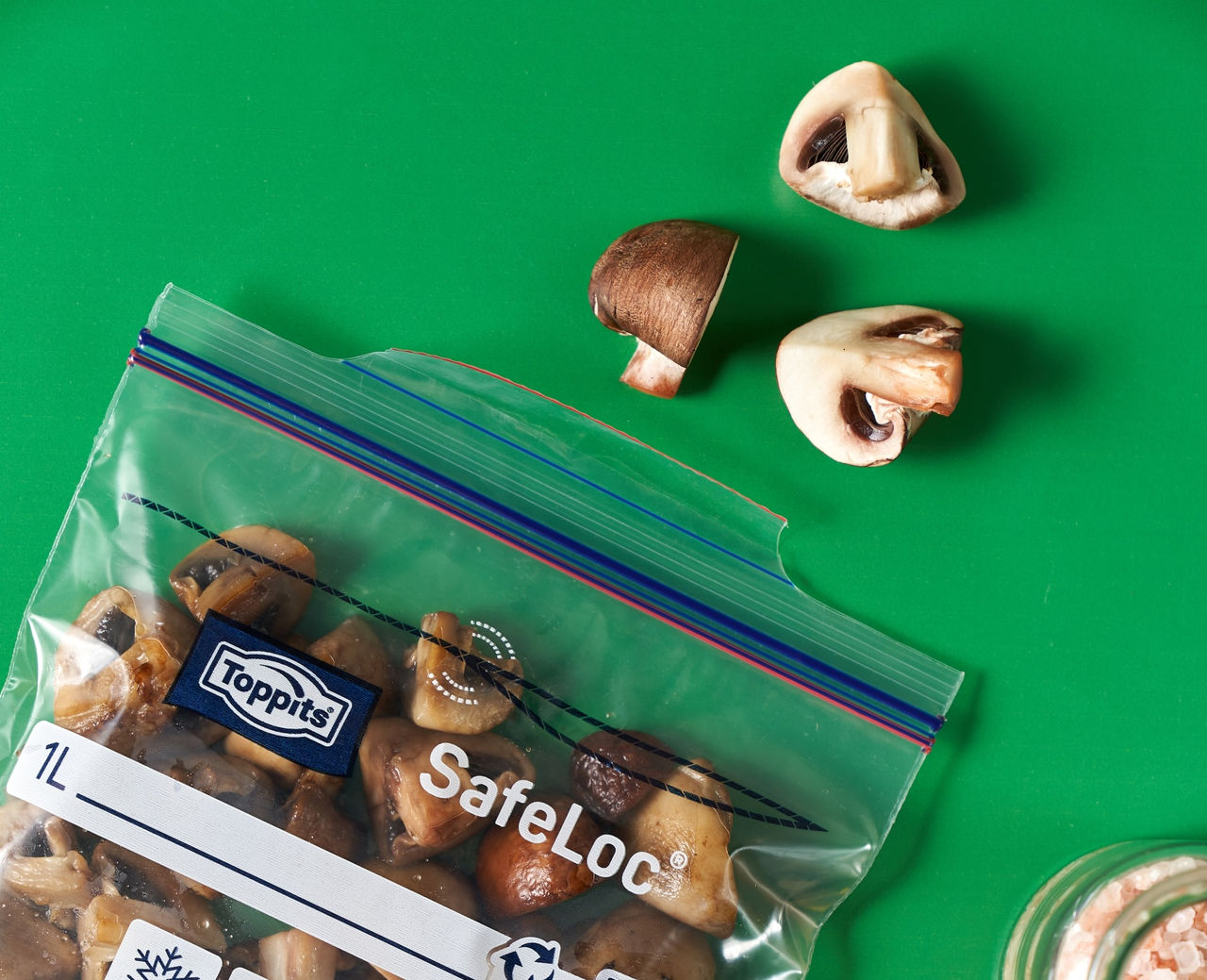 Gegarte Champignons in einem Toppits SafeLoc Beutel, daneben einzelne Pilzstücke.